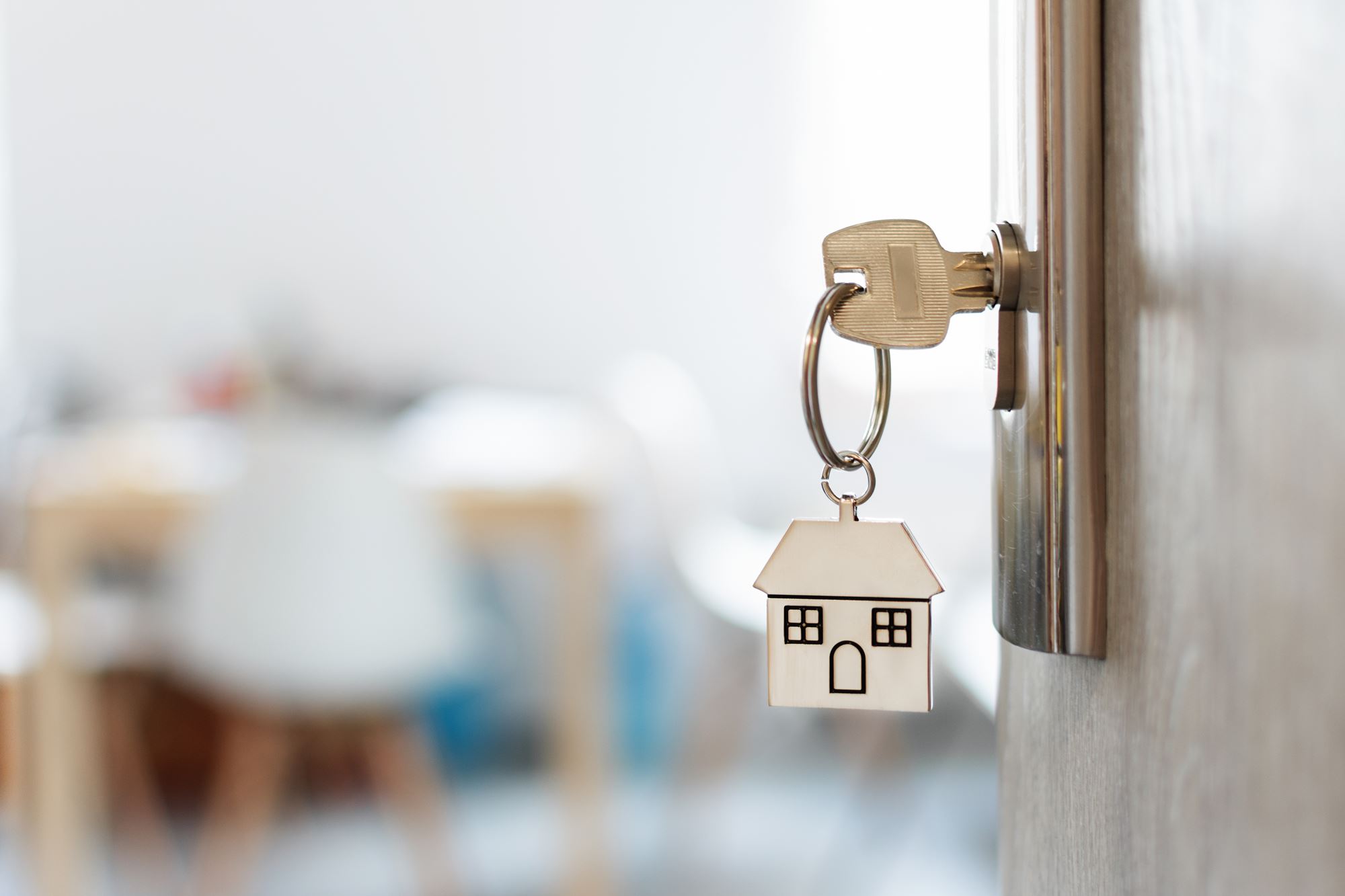 Key inserted into a door with a house keychain.